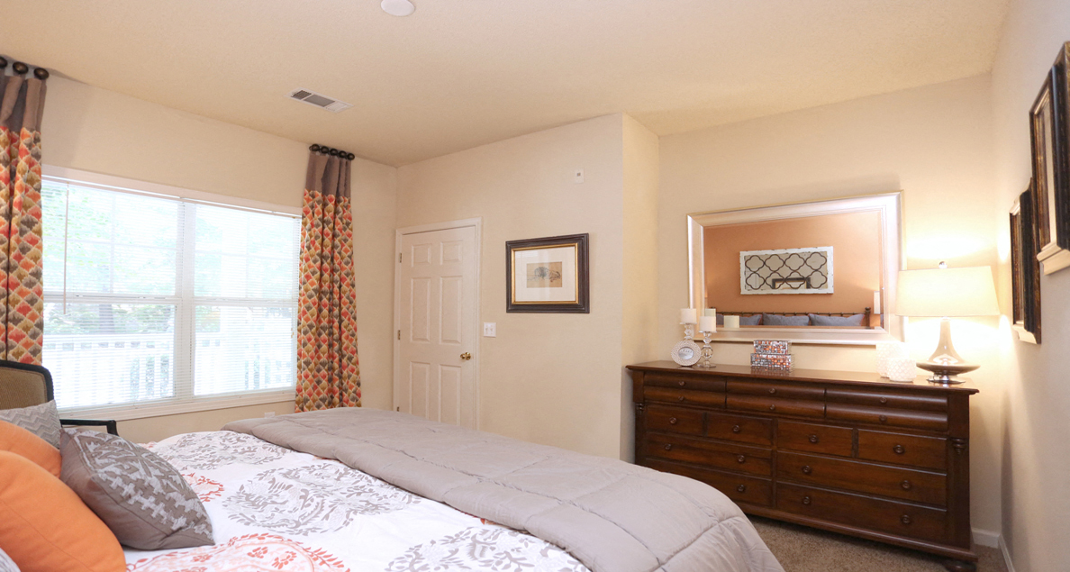 Airy main bedroom with large windows and modern furniture at The Columns at Hiram, Georgia